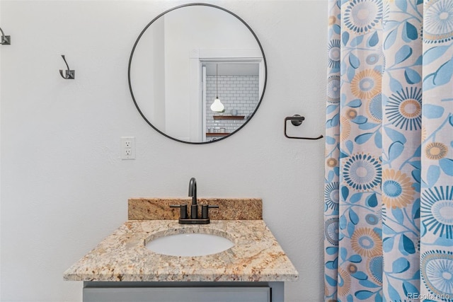 bathroom featuring a shower with shower curtain and vanity