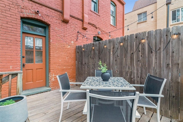 deck with outdoor dining area and fence