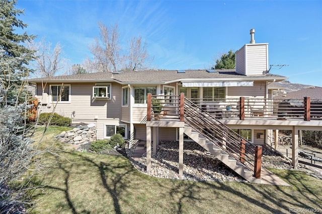 back of property with a deck, stairway, a yard, and a chimney