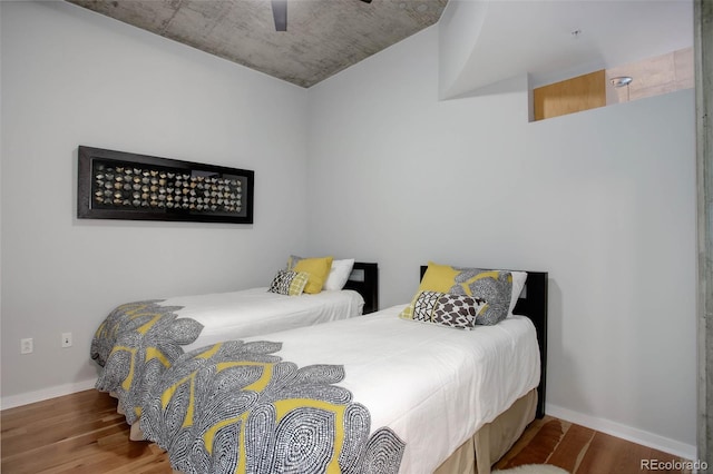 bedroom with a ceiling fan, baseboards, and wood finished floors