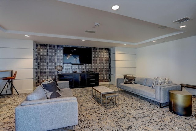 living area with visible vents, a tray ceiling, and recessed lighting