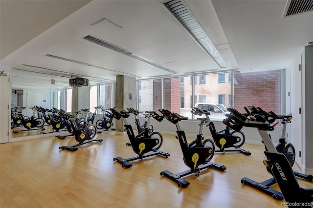 gym with visible vents, baseboards, and wood finished floors