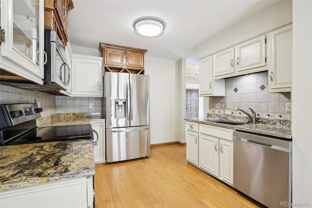 10469 Christopher Dr, Conifer, CO 80433 - kitchen featuring appliances with stainless steel finishes, a sink, decorative backsplash, and light wood-style flooring