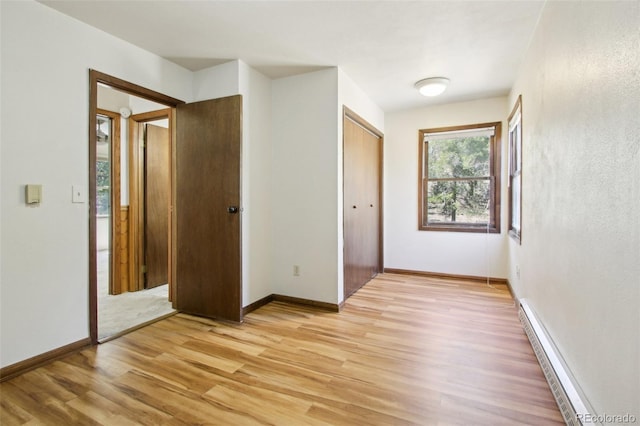 10469 Christopher Dr, Conifer, CO 80433 - unfurnished bedroom with light wood finished floors, baseboards, a baseboard heating unit, and a closet