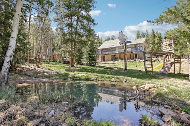 10469 Christopher Dr, Conifer, CO 80433 - back of property with a playground, a yard, and a chimney