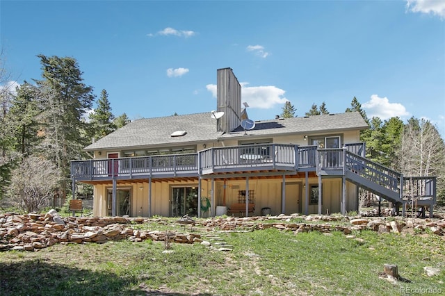 10469 Christopher Dr, Conifer, CO 80433 - back of house with board and batten siding, a wooden deck, stairway, and a chimney