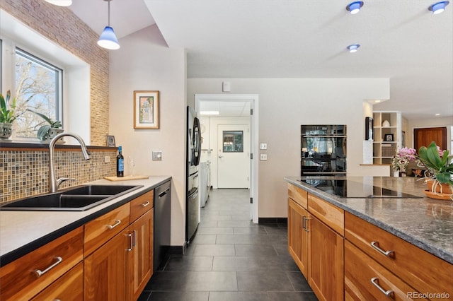 kitchen featuring sink, backsplash, hanging light fixtures, black appliances, and dark tile patterned flooring