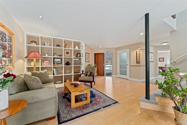 living room with a textured ceiling and light wood-type flooring