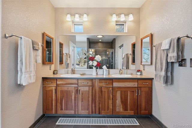 bathroom with an enclosed shower, vanity, and tile patterned floors