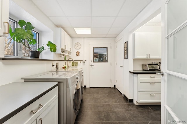 washroom featuring cabinets, washing machine and clothes dryer, dark tile patterned flooring, and sink