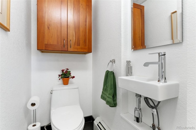 bathroom with sink, toilet, and baseboard heating