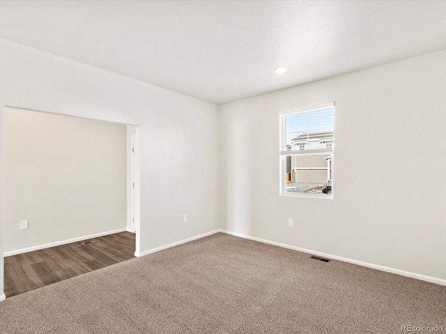 carpeted empty room with visible vents and baseboards