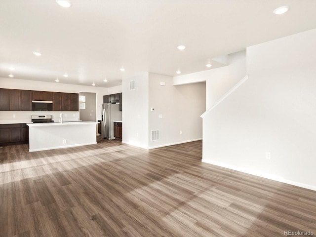 unfurnished living room featuring recessed lighting, visible vents, a sink, and wood finished floors