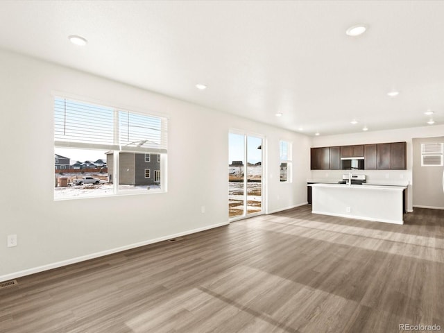 unfurnished living room featuring baseboards, wood finished floors, and recessed lighting