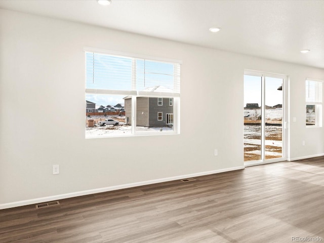 empty room featuring recessed lighting, visible vents, baseboards, and wood finished floors