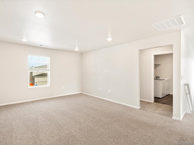 carpeted empty room featuring baseboards, visible vents, separate washer and dryer, and recessed lighting