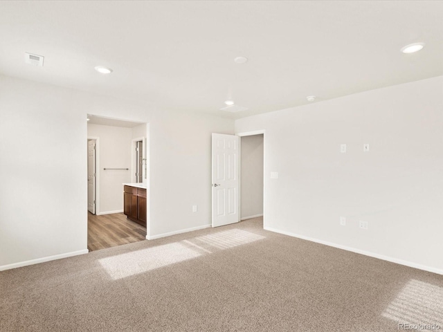 spare room with baseboards, recessed lighting, visible vents, and light colored carpet