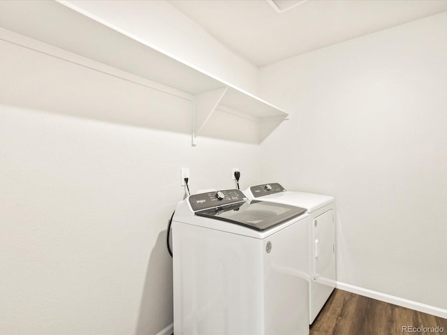 laundry area with laundry area, baseboards, washer and clothes dryer, and dark wood-style flooring