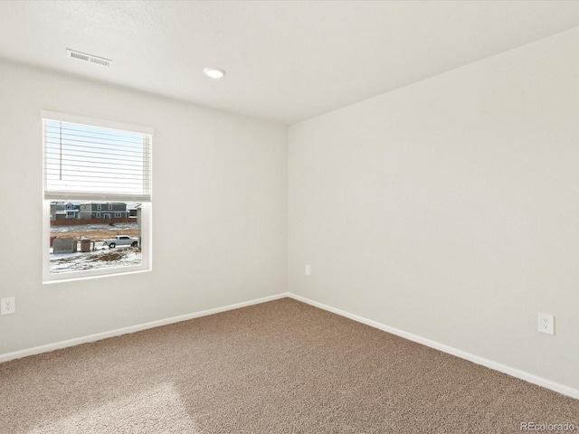 carpeted spare room with visible vents, baseboards, and recessed lighting