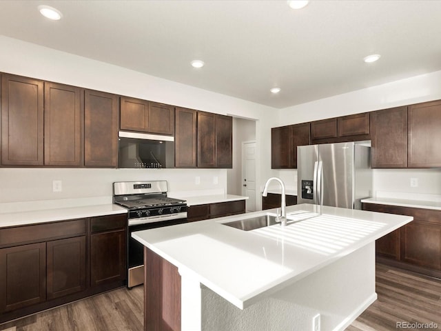 kitchen with dark wood-style floors, stainless steel appliances, a sink, and light countertops