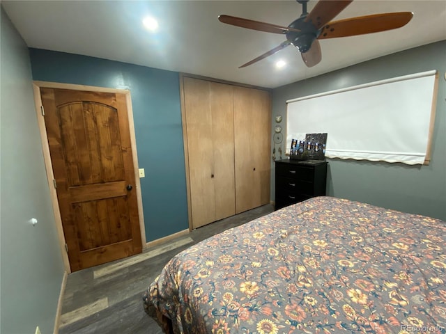 bedroom featuring dark wood-type flooring, ceiling fan, and a closet