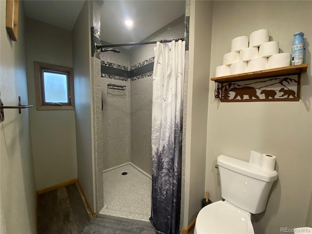 bathroom featuring hardwood / wood-style flooring, toilet, and curtained shower