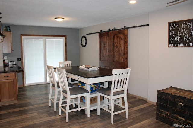 dining area featuring a barn door and dark hardwood / wood-style flooring