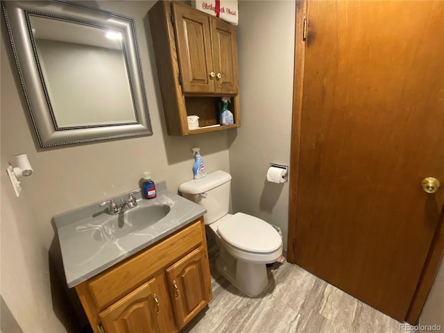 bathroom with vanity, hardwood / wood-style floors, and toilet