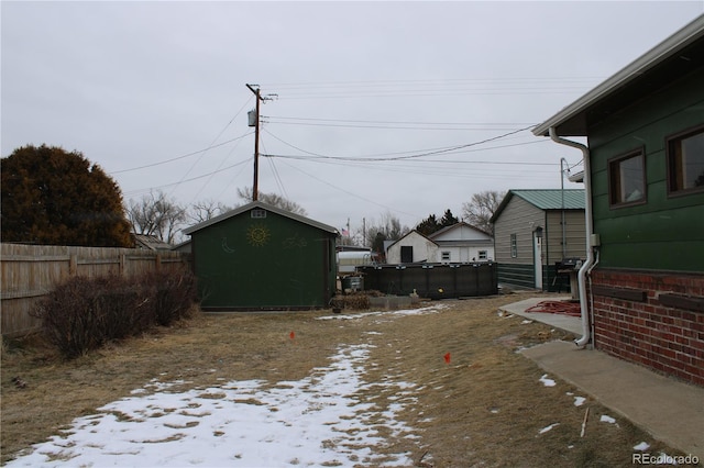 yard layered in snow featuring a storage shed