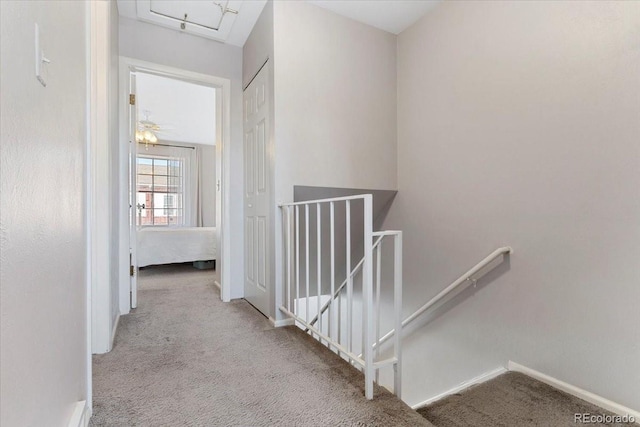 corridor with carpet flooring, an upstairs landing, and baseboards