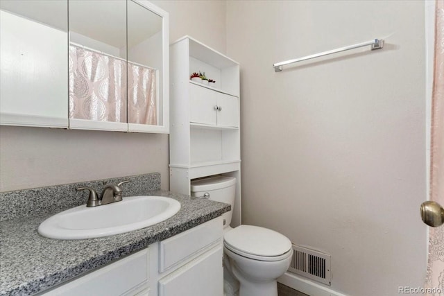 full bathroom featuring vanity, toilet, and visible vents