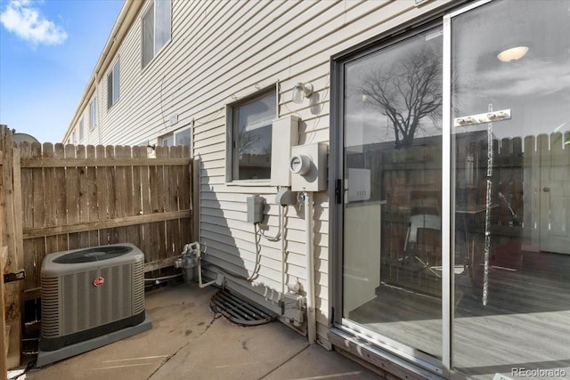 view of side of property featuring central AC and fence