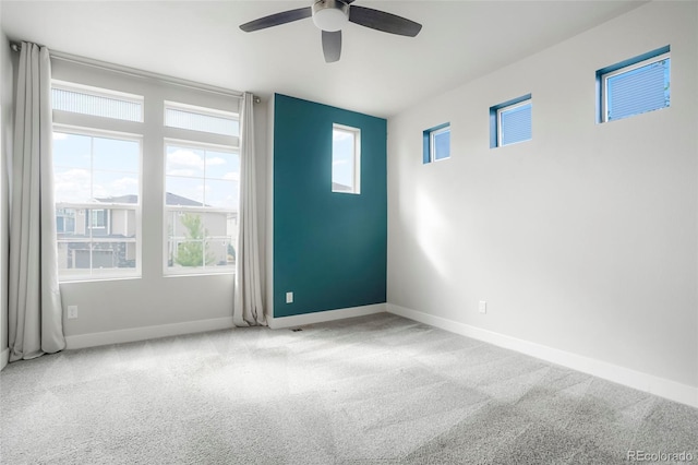 spare room with ceiling fan and light colored carpet