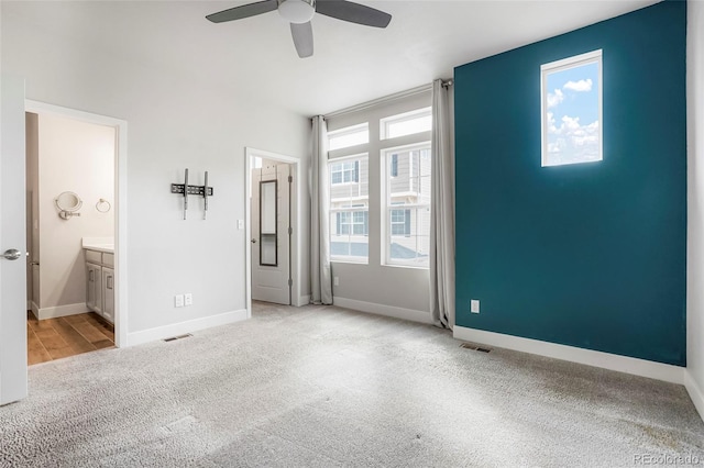 unfurnished bedroom with connected bathroom, ceiling fan, and light hardwood / wood-style flooring