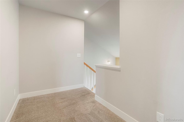 corridor with light carpet and lofted ceiling