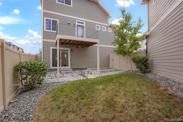 back of house with a patio, a lawn, and a balcony