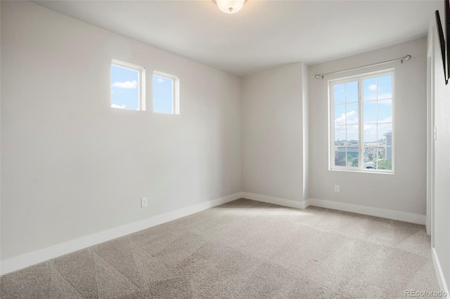 unfurnished room featuring a wealth of natural light and carpet