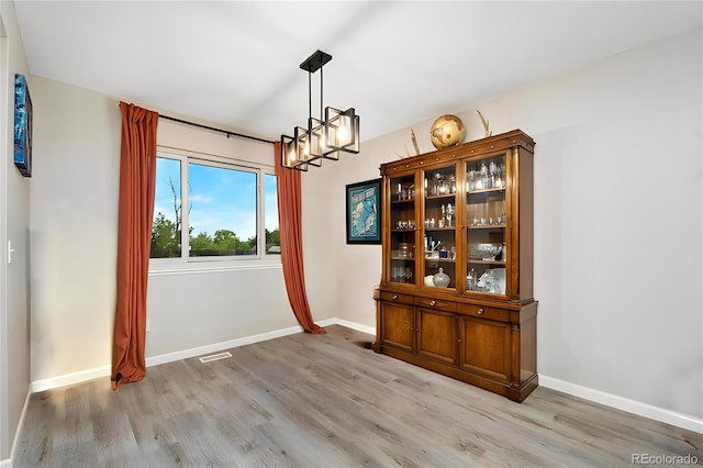 2954 E 101st Ave, Thornton, CO 80229 - unfurnished dining area featuring a chandelier, light wood-type flooring, and baseboards