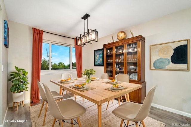 2954 E 101st Ave, Thornton, CO 80229 - dining area with wood finished floors, a chandelier, and baseboards