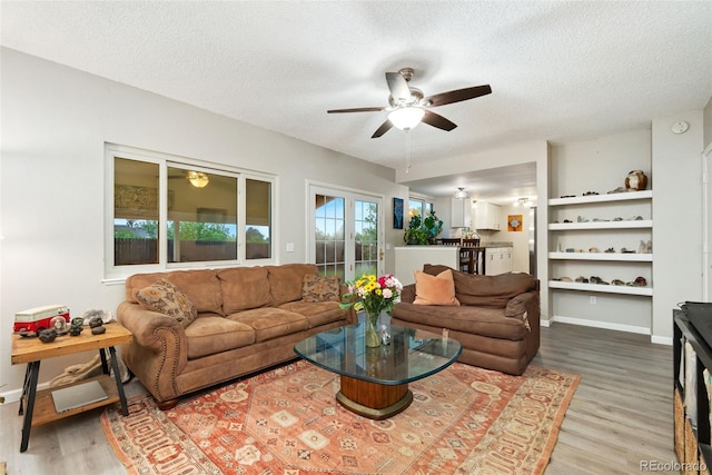 2954 E 101st Ave, Thornton, CO 80229 - living room featuring a ceiling fan, wood finished floors, a textured ceiling, and baseboards