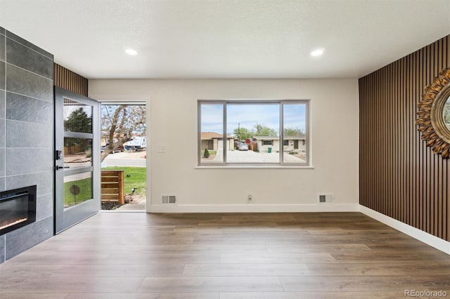 2840 Cottonwood Dr, Denver, CO 80221 - unfurnished living room featuring a healthy amount of sunlight, visible vents, and wood finished floors