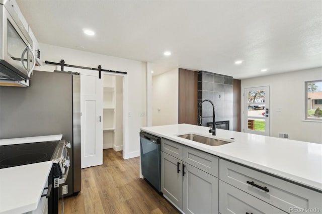 2840 Cottonwood Dr, Denver, CO 80221 - kitchen with a sink, black dishwasher, gray cabinets, a barn door, and stainless steel microwave