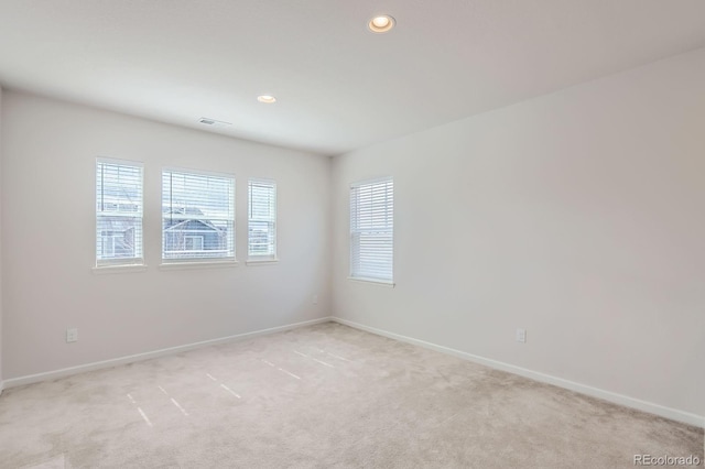 unfurnished room featuring recessed lighting, baseboards, and light carpet