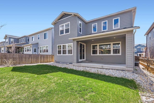 back of property with a lawn, a fenced backyard, and a patio area