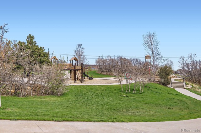 view of property's community with a lawn and playground community
