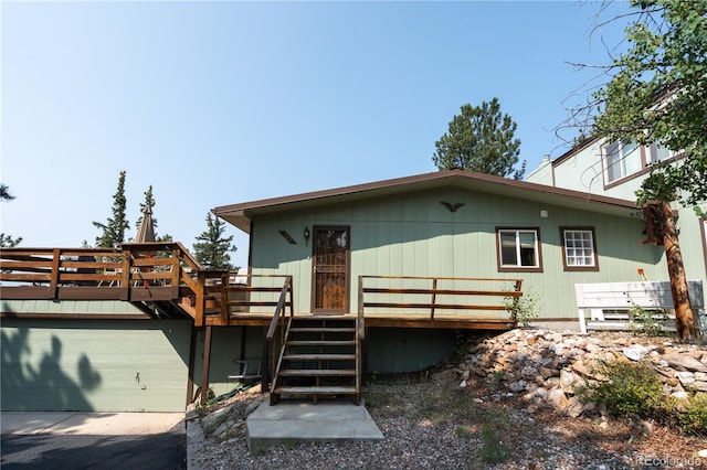 back of house with a garage and a wooden deck