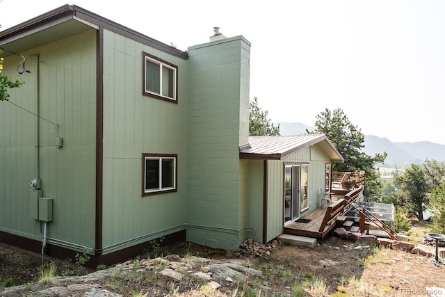 view of property exterior with a deck with mountain view