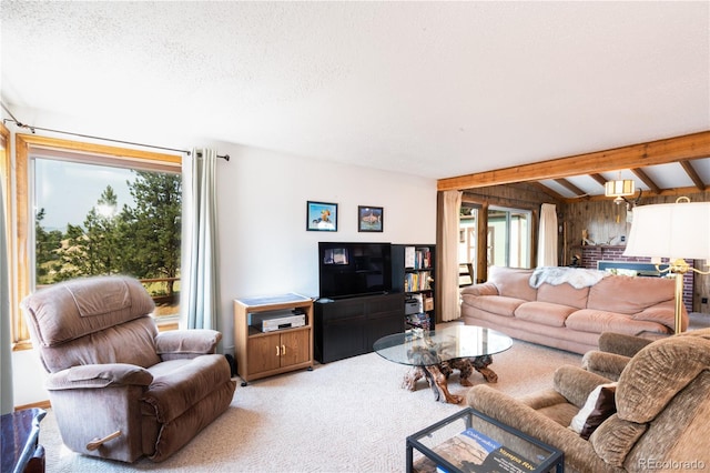 carpeted living room with a textured ceiling, wooden walls, and beamed ceiling