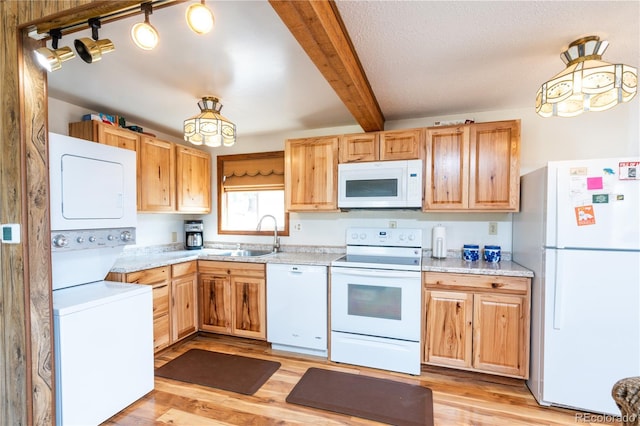 kitchen with sink, light wood-type flooring, stacked washer and dryer, white appliances, and beam ceiling