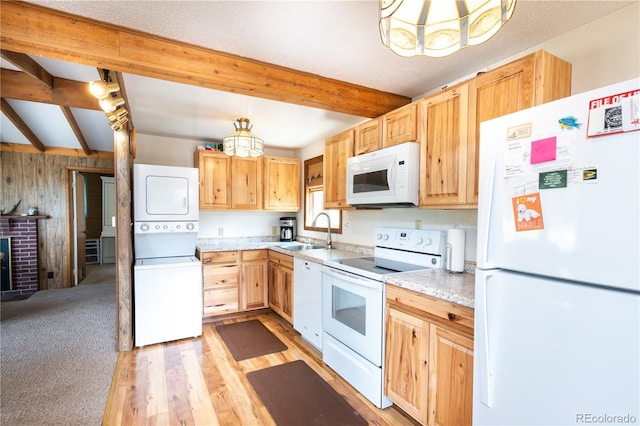 kitchen featuring stacked washer / dryer, sink, white appliances, and beamed ceiling